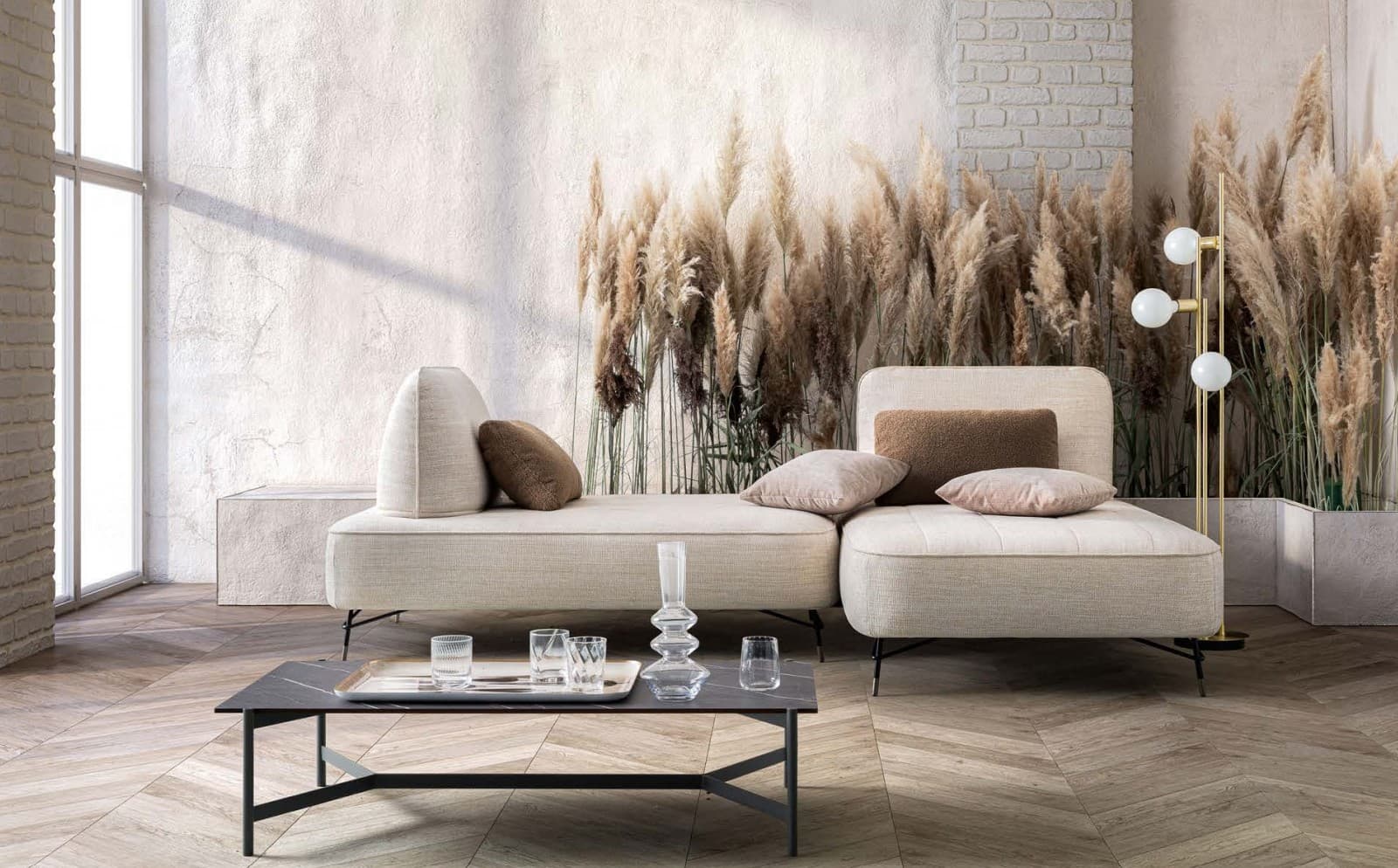 Divano modulare beige in ambiente luminoso con pampa